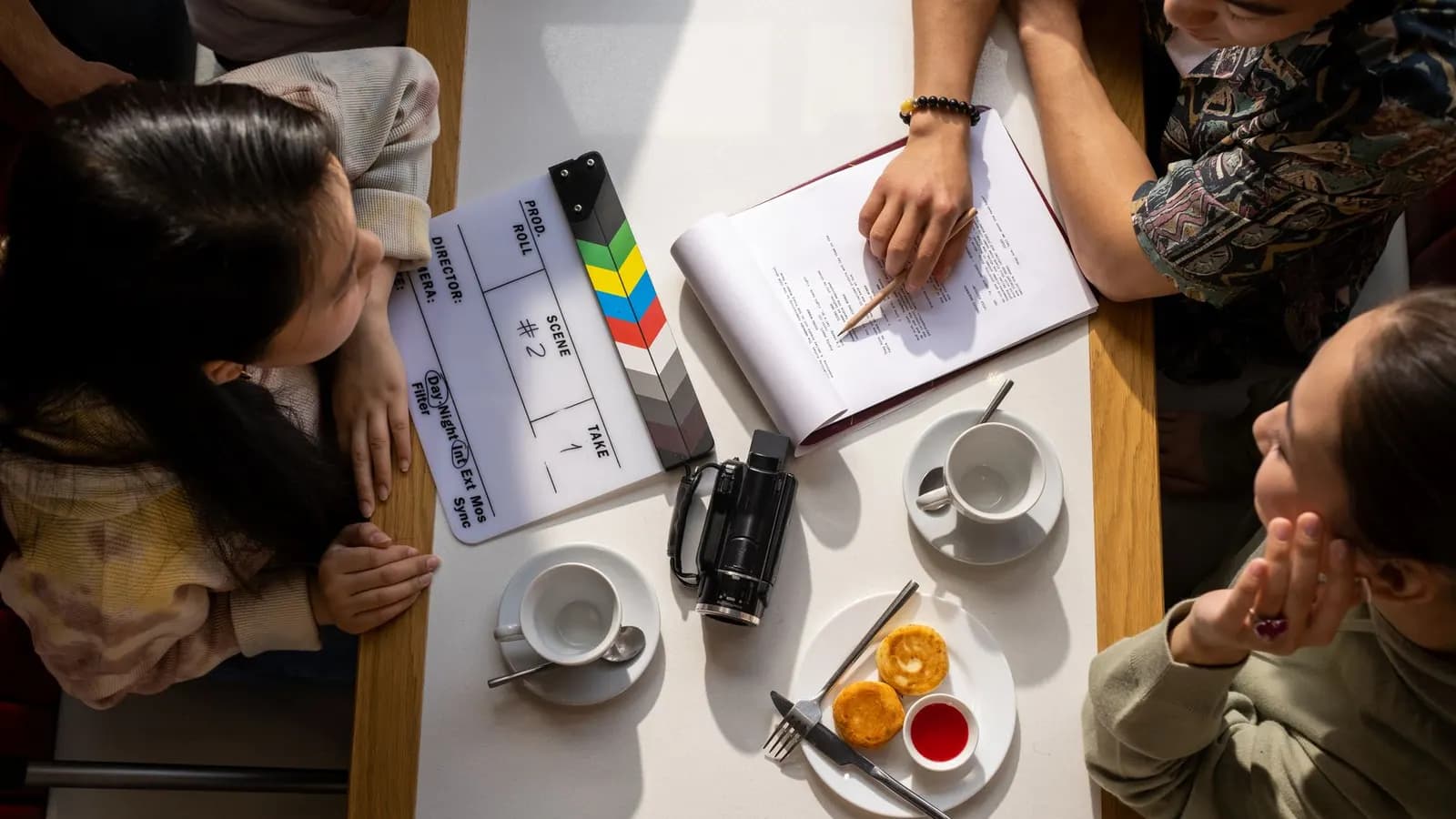 Papan klapper film di atas meja bersama buku catatan