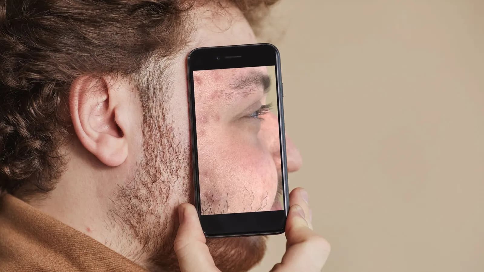 Wajah seseorang terpantul di layar digital dalam ruangan gelap