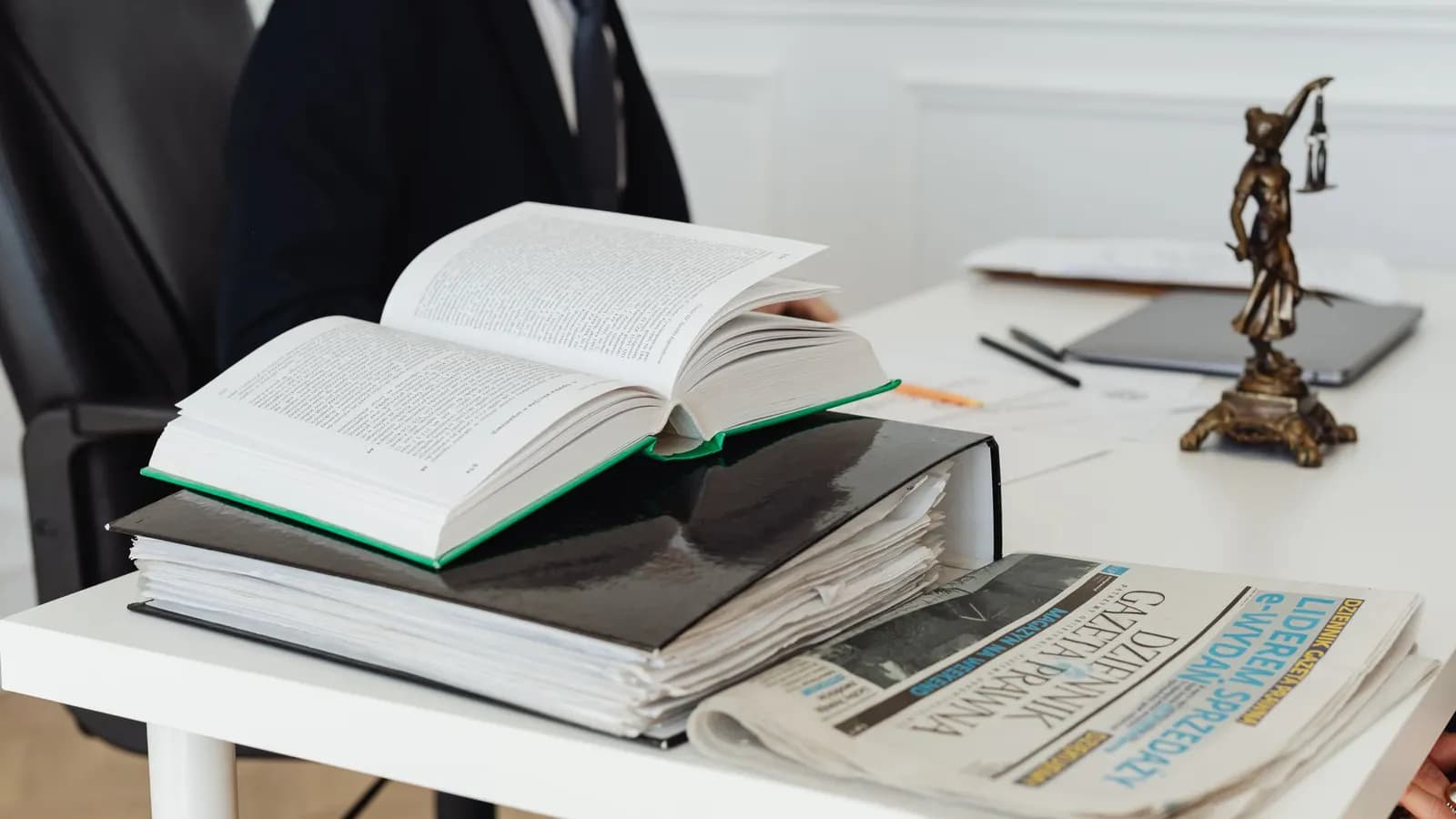Tumpukan buku hukum di atas meja kerja dengan lampu baca