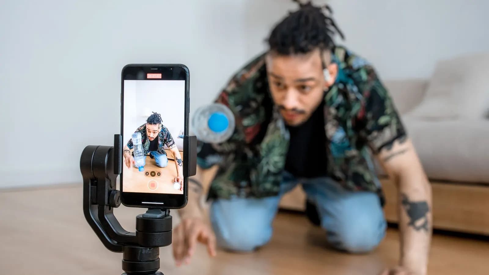 Seseorang merekam video vertikal dengan ponsel yang dipasang pada tripod