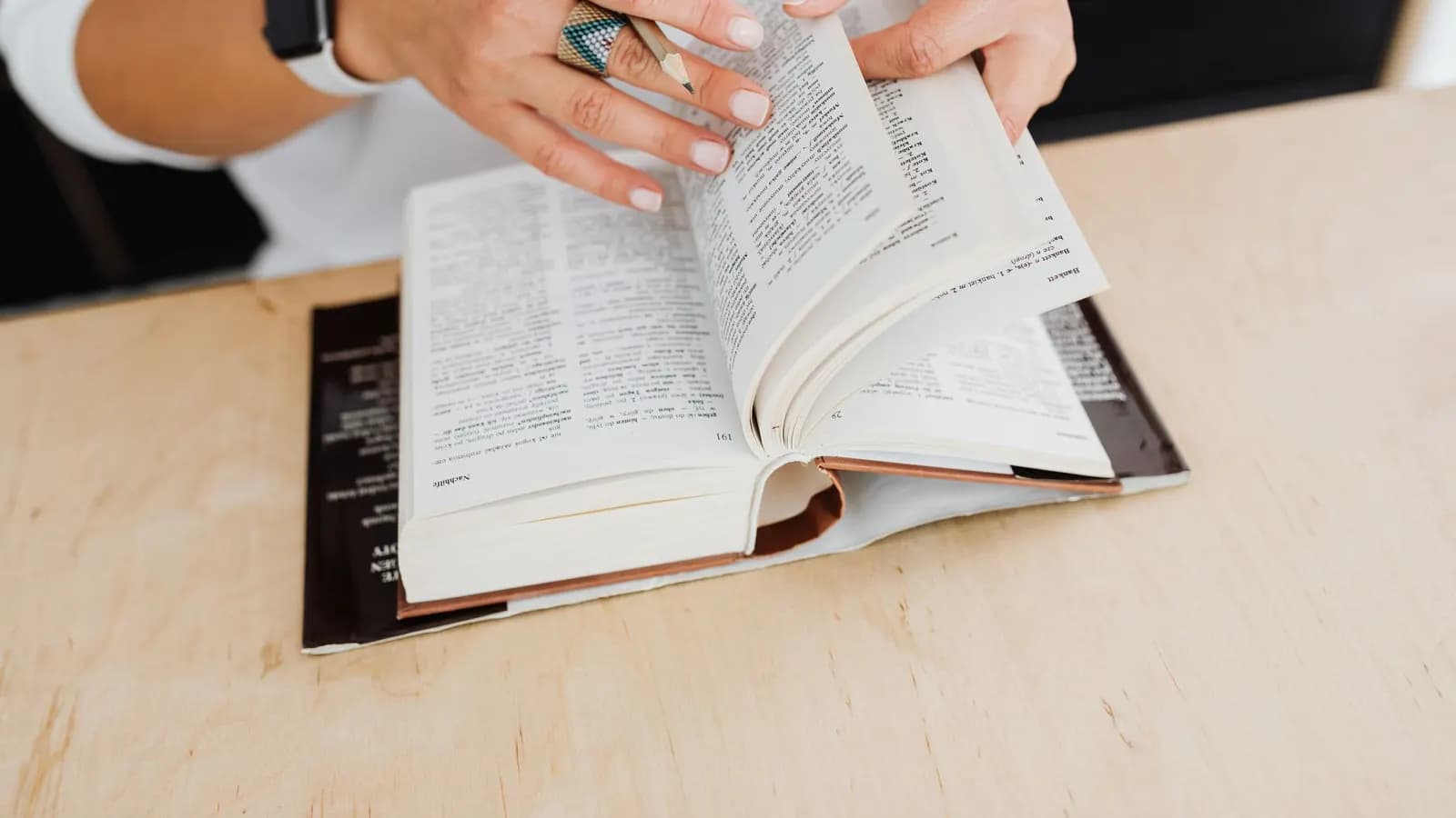 Tumpukan buku kamus di atas meja belajar