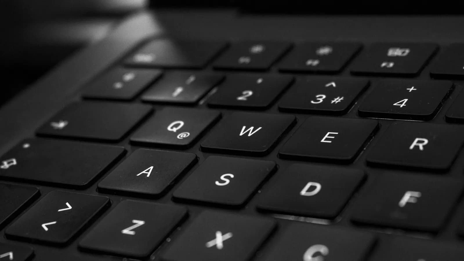 Tangan seseorang mengetik di papan ketik laptop